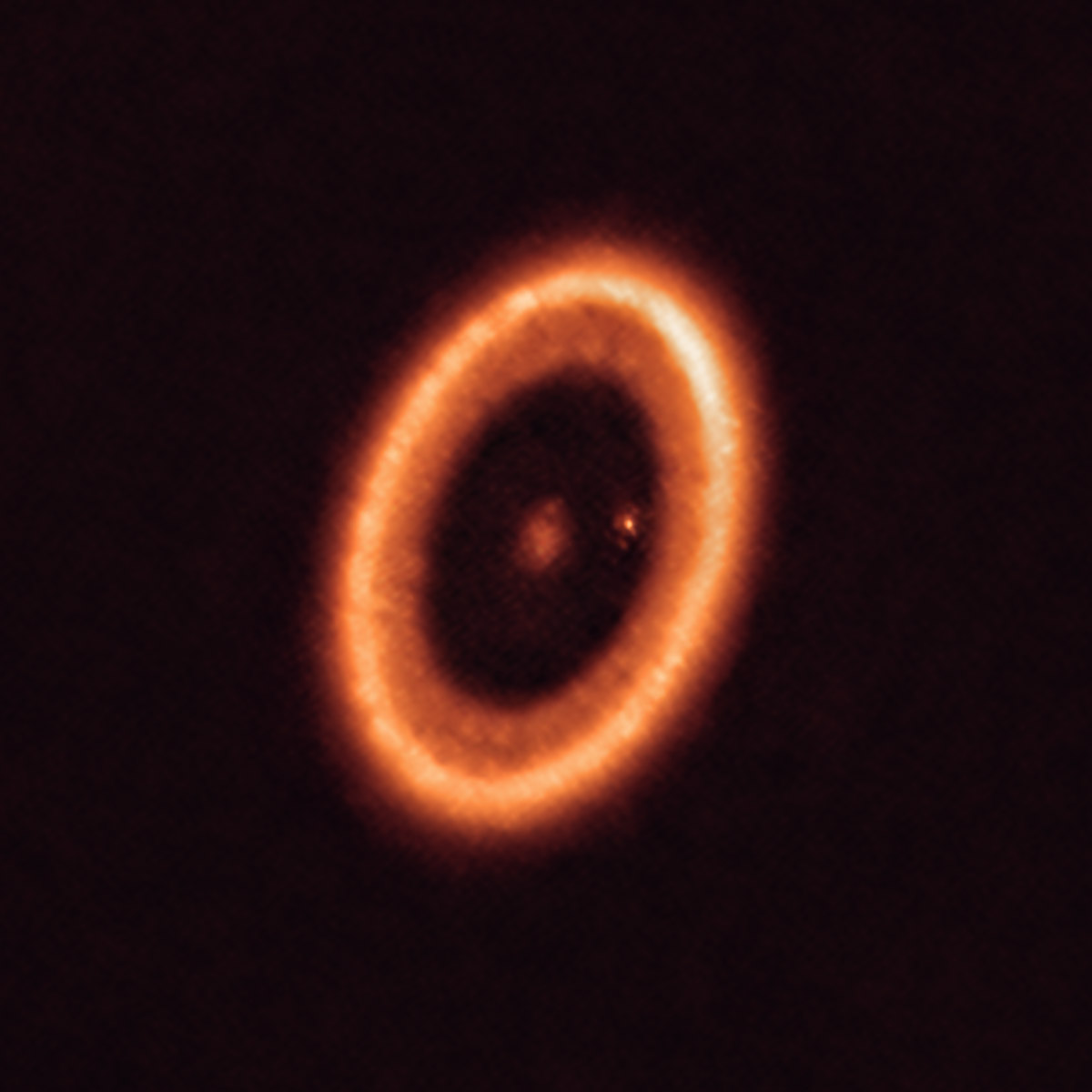 This image shows the PDS 70 system, located nearly 400 light-years away and still in the process of being formed. The system features a star at its center, and at least two planets orbiting it, called PDS 70b (not visible in the image) and PDS 70c (the dot to the right of the star). The planets have carved a cavity in the circumstellar disk (the ring-like structure that dominates the image) as they gobbled up material from the disk itself, growing in size. In this process, PDS 70c acquired its own circumplanetary disk, which contributes to the growth of the planet and where moons can form.