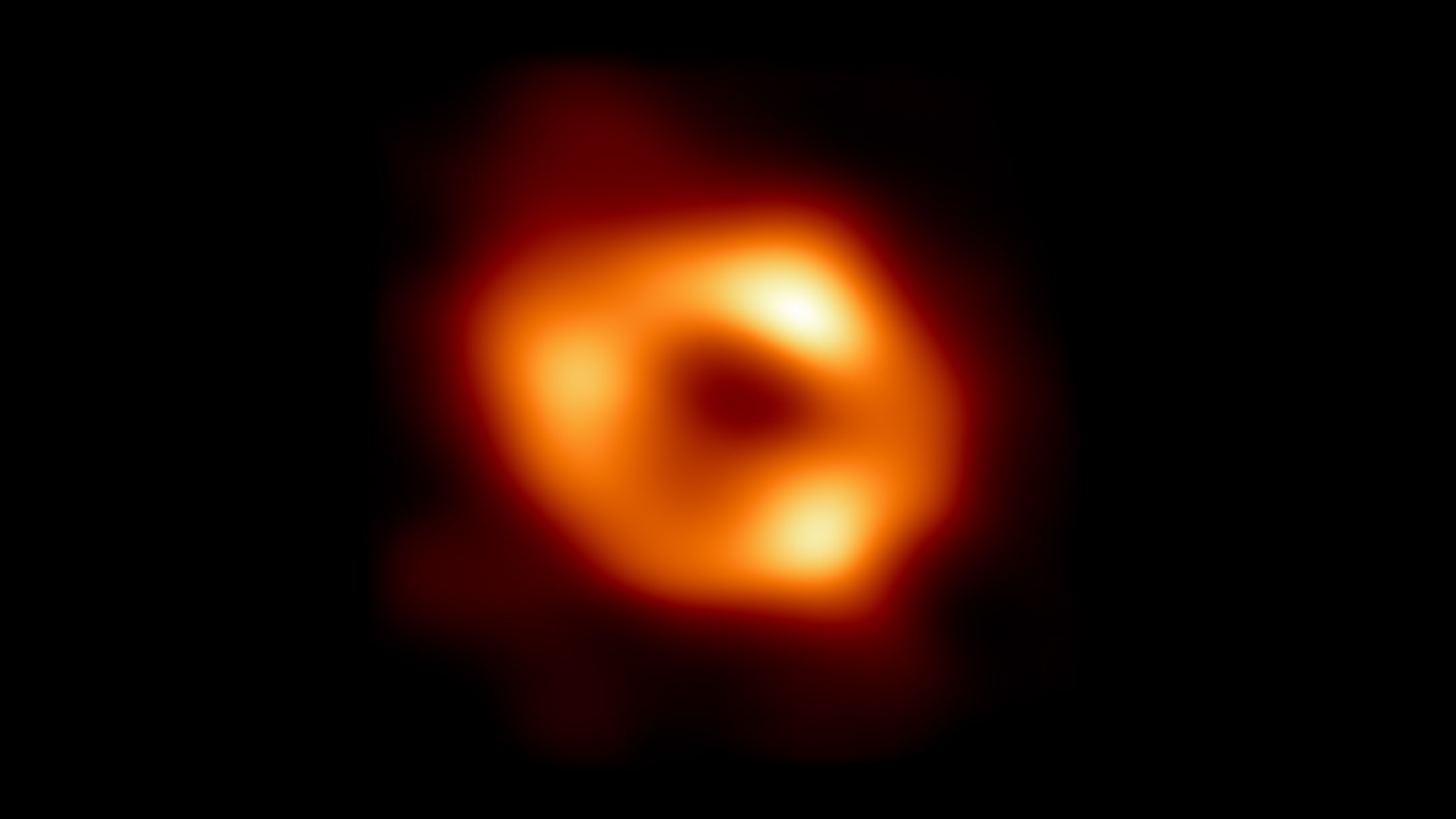 First image of the black hole at the center of the Milky WayThis is the first image of Sagittarius A* (or Sgr A* for short), the supermassive black hole at the center of our galaxy. It's the first direct visual evidence of the presence of this black hole. It was captured by the Event Horizon Telescope (EHT), an array which linked together eight existing radio observatories across the planet to form a single "Earth-sized" virtual telescope. The telescope is named after the "event horizon," the boundary of the black hole beyond which no light can escape.Although we cannot see the event horizon itself, because it cannot emit light, glowing gas orbiting around the black hole reveals a telltale signature: a dark central region (called a "shadow") surrounded by a bright ring-like structure. The new view captures light bent by the powerful gravity of the black hole, which is four million times more massive than our Sun. The image of the Sgr A* black hole is an average of the different images the EHT Collaboration has extracted from its 2017 observations.