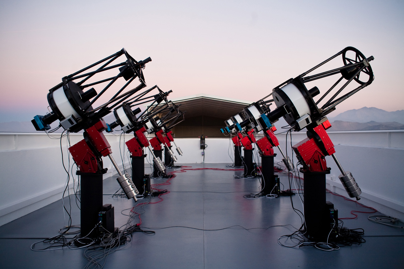 The MEarth-South telescope array, located on Cerro Tololo in Chile, searches for planets by monitoring the brightness of nearby, small stars. This photograph shows the array, comprising eight 40-cm telescopes, at twilight. (The MEarth team grants unrestricted permission for reuse and redistribution of this image.)