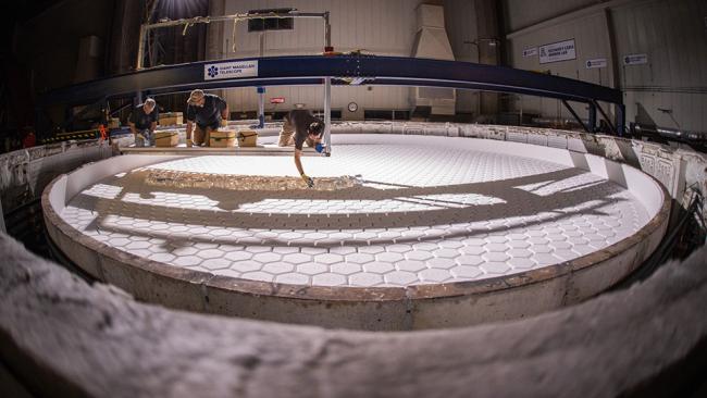 University of Arizona Richard F. Caris Mirror Lab staff members placing chunks of Ohara E6 low expansion glass into a mold for casting primary mirror segment seven, September 2023. 