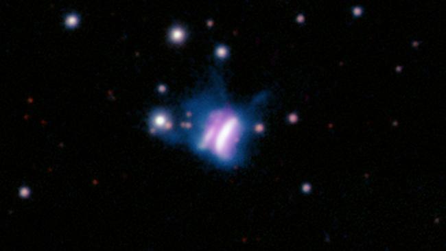  The center of this composite image shows IRAS 23077, likely the largest planet-forming disk ever seen, which looks like a giant cosmic butterfly. 